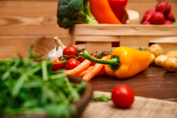 Sweet pepper, carrot and cherry tomatoes. Potatoes, brocoli and red radish. Natural raw vegetables. Organic bio food on rustic wooden table.