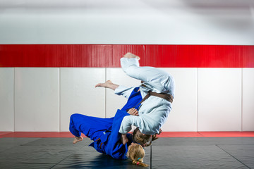 Two women fight judo on tatami