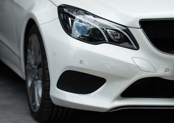 Obraz na płótnie Canvas Close-up view of white sports car headlight.