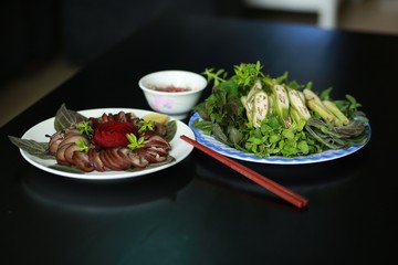 Steamed dog meat with herbs and sauces in Vietnam