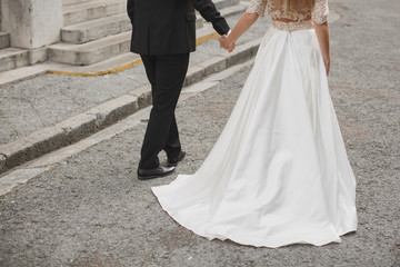 Bride and groom walking together holding their hands