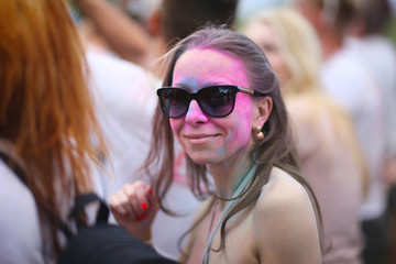 Portrait of a painted woman among people at the Holi paints festival.