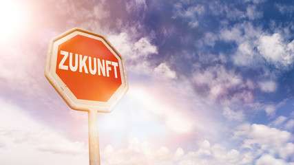 Zukunft auf rotem Stoppschild vor blauem Wolkenhimmel