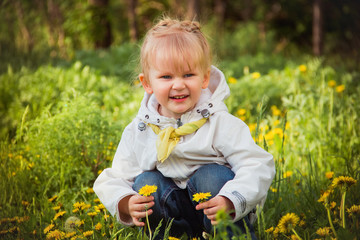little girl on the dandelions meadow in spring day