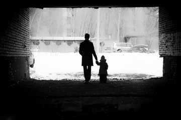 a man holds the hand of a girl winter background silhouette