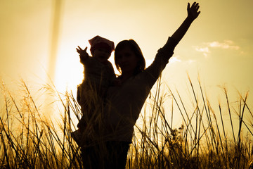mother and little daughter silhouettes at sunset