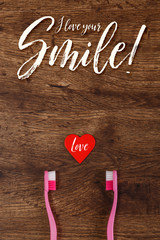 Lesbian couple love concept with heart and toothbrushes. Valentines day design on wood vintage background. Love your smile.