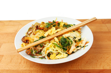 Singapore noodles with chopsticks in a bowl