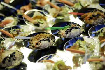 finger food: vari antipasti dentro piattini neri con cucchiaini colorati