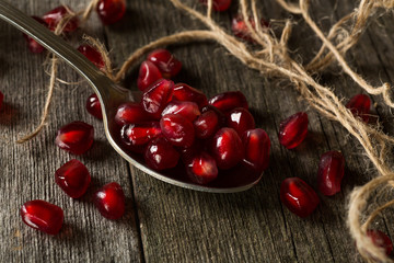 pomegranate seeds in a spoon on the table