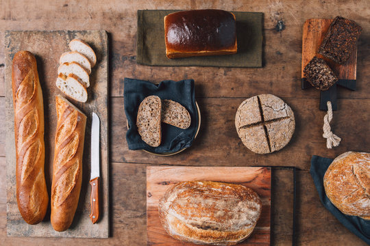 From above photo of bread on cutting board on wooden table.