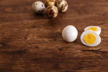 Quail eggs. Raw and boiled sliced food. Natural organic eco eggs. Wooden rustic background.