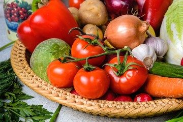 A variety of vegetables in wicker basket in the foreground a bra