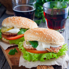 Homemade hamburger with beef, onions, tomatoes, salad and cheese on a wooden board, Square