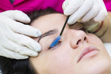 Woman on the procedure for eyelash extensions, eyelashes lamination 