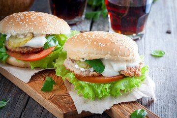 Homemade hamburger with beef, onions, tomatoes, salad and cheese on a wooden board, Horizontal
