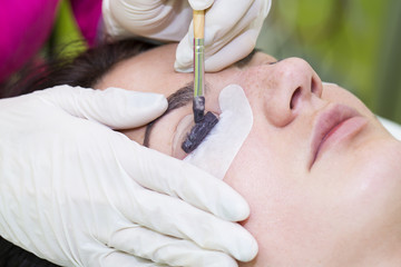 Woman on the procedure for eyelash extensions, eyelashes lamination 