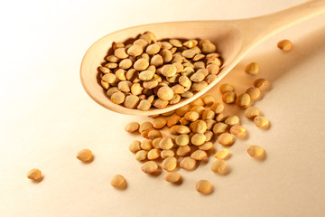 Raw lentil in wooden spoon