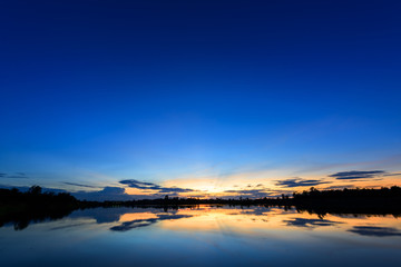 Breathtaking sunset over lake with blue sky