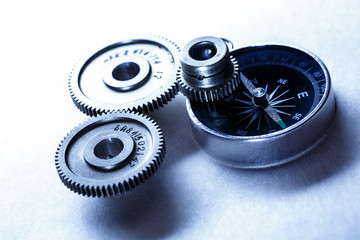 Three steel cogwheels with compass