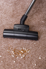 Vacuuming carpet with vacuum cleaner. Dirt on the rug. Housework service. Close up of the head of a sweeper cleaning device.