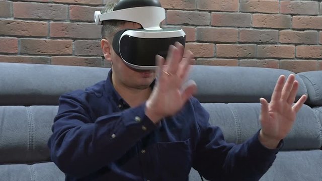 Man wearing virtual reality goggles. Studio shot, couch.Technology VR - Mature businessman wearing virtual reality technology googles