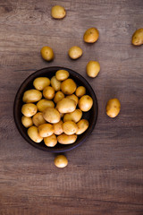 Potatoes in a rustic plate. Raw new potato. Fresh natural vegetables. Organic bio food on wooden table.