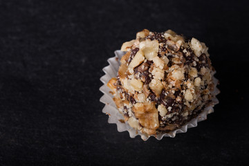 One chocolate candy on a slate background