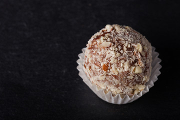 One chocolate candy on a slate background