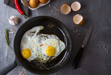 fried eggs iron frying pan rosemary spice pepper
