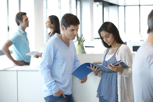 Colleagues looking over pamphlet together