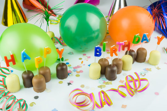 Happy Birthday, viele kleine Schaumküsse mit Geburtstagskerzen und Luftballons, Konfetti und Luftschlangen