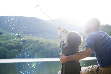 Father and son fishing, boy caught fish in fishing net