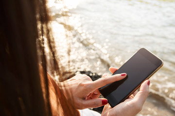 Woman using Smart Phone on summer Beach