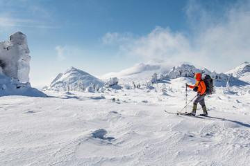 Naklejka na ściany i meble ski mountaineering on snowy mountain landscape. Winter hiking concept