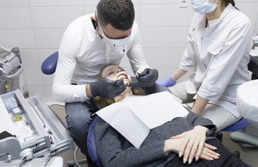 Dental cure. Molar treatment. Young female patient visiting dentist office. 