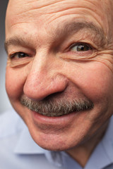 old man with a mustache looks curiously