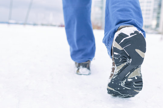 Man going in sneakers. Close picture of running man in winter