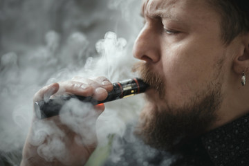 Man portrait smoking an electronic cigarette