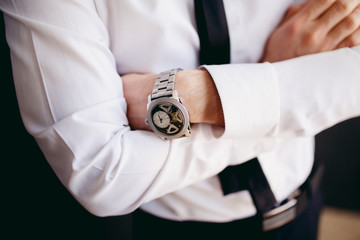 A close-up of a businessman in a white shirt and a black tie. Dark background