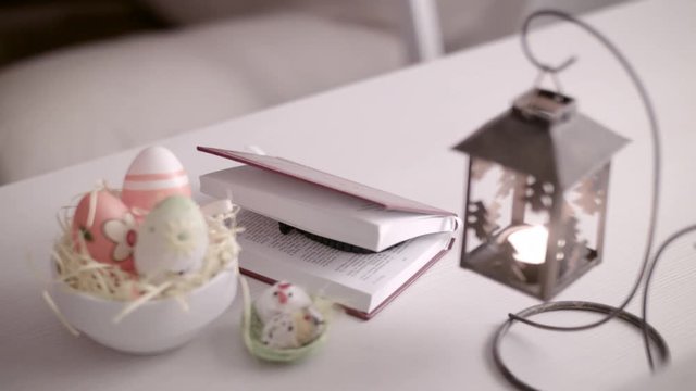 Easter eggs in white  basket .Easter decoration.Man's hands closed  Bible next to Easter eggs