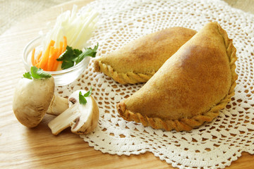 Russian pirozhki, baked patties or pies on basket with cheese and mushrooms
