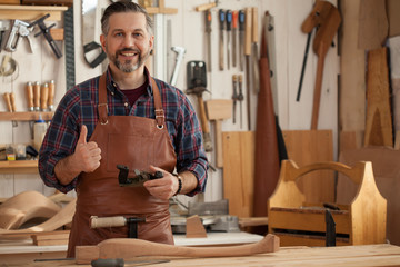 Joiner Makes Cabriole Leg for Vintage Table/Carpenter works with a planer in a workshop for the...