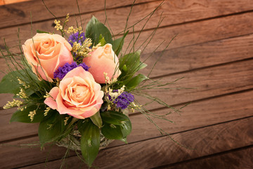 Bouquet of pink roses on rustic wooden table