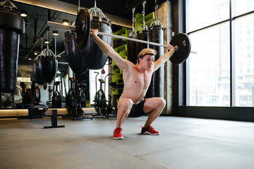 Athletic man doing exercise with barbell