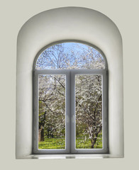 white semicircular modernist windows on a white wall.spring, flowers, cherry, apple, grass in the window