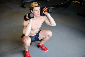 Top view of Muscular man doing exercise with dumbbells