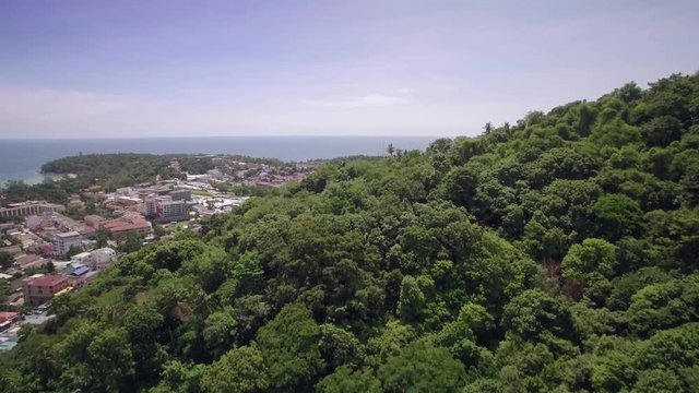 Drone Flying Over Rainforest Covered Hills Approaching Kata and Karon in Phuket Thailand
