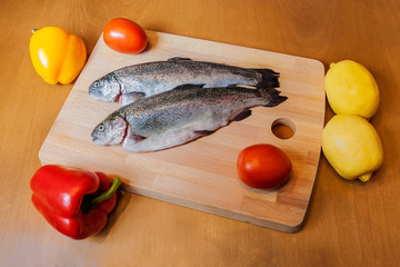 Fresh trouts on wooden cutting board