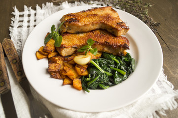 Turkey with spinach and pumpkin on a wooden table